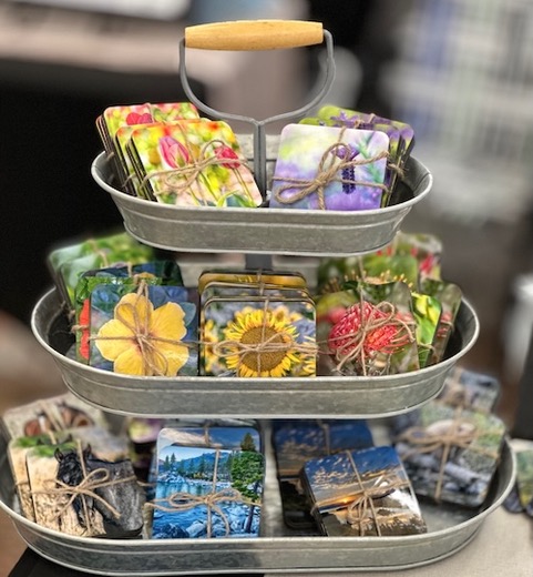 A display of several packs coasters with images of flowers, animals, and nature.