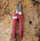 Pruning shears on a marble counter. An arrow points to the base of the handles.