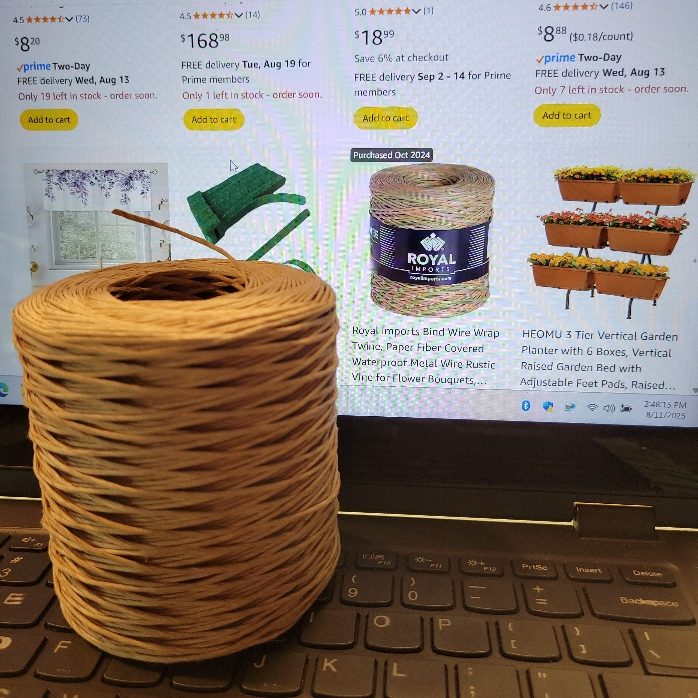 A roll of paper-wrapped wire on a laptop.