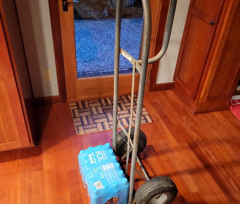 A hand truck carrying a pack of water.