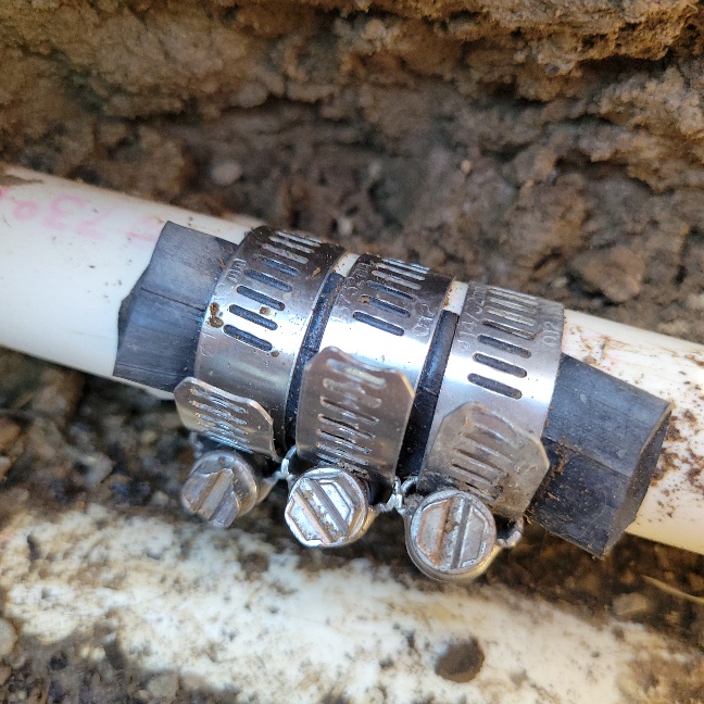 Three clamps squeezing a bike inner tube over the pipe.