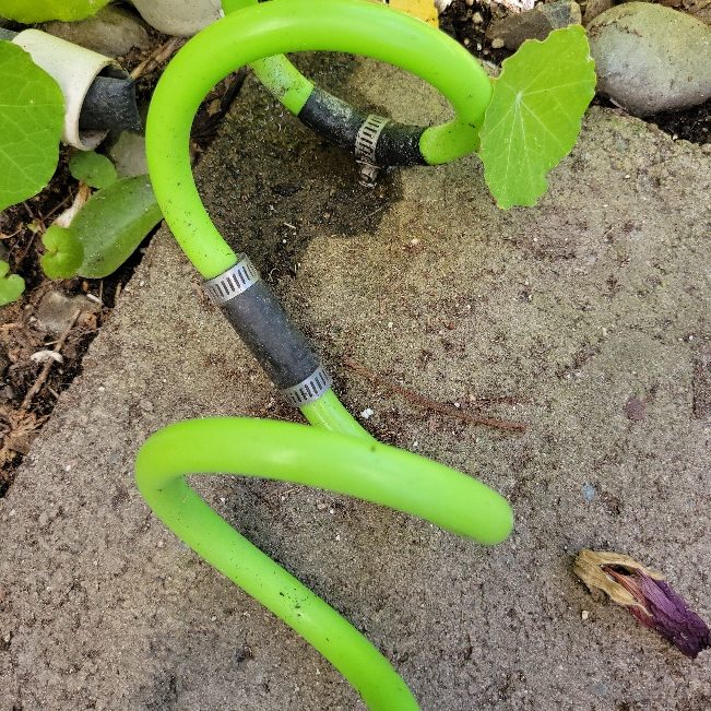 A green hose with a couple repairs.