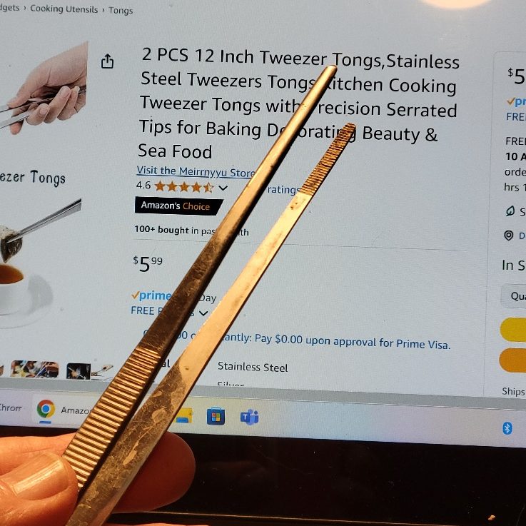 A person holding a pair of tweezers in front of an Amazon product page: 2 PCS 12 Inch Tweezer Tongs for $5.99.